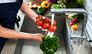 Hands woman washing vegetables. Preparation of fresh salad.